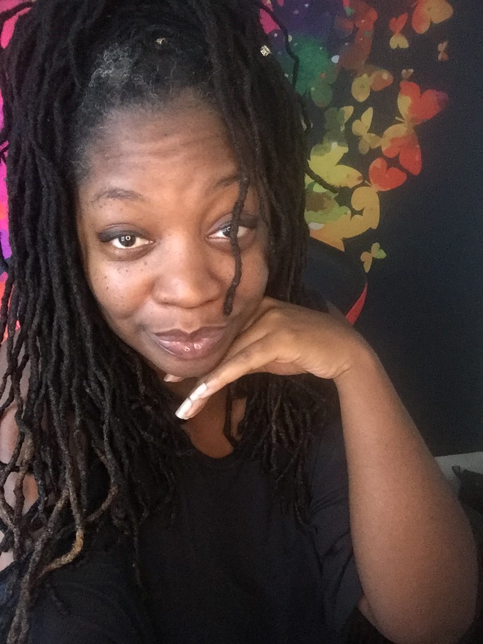 Image of Aaminah Sai with her left hand framing her face.